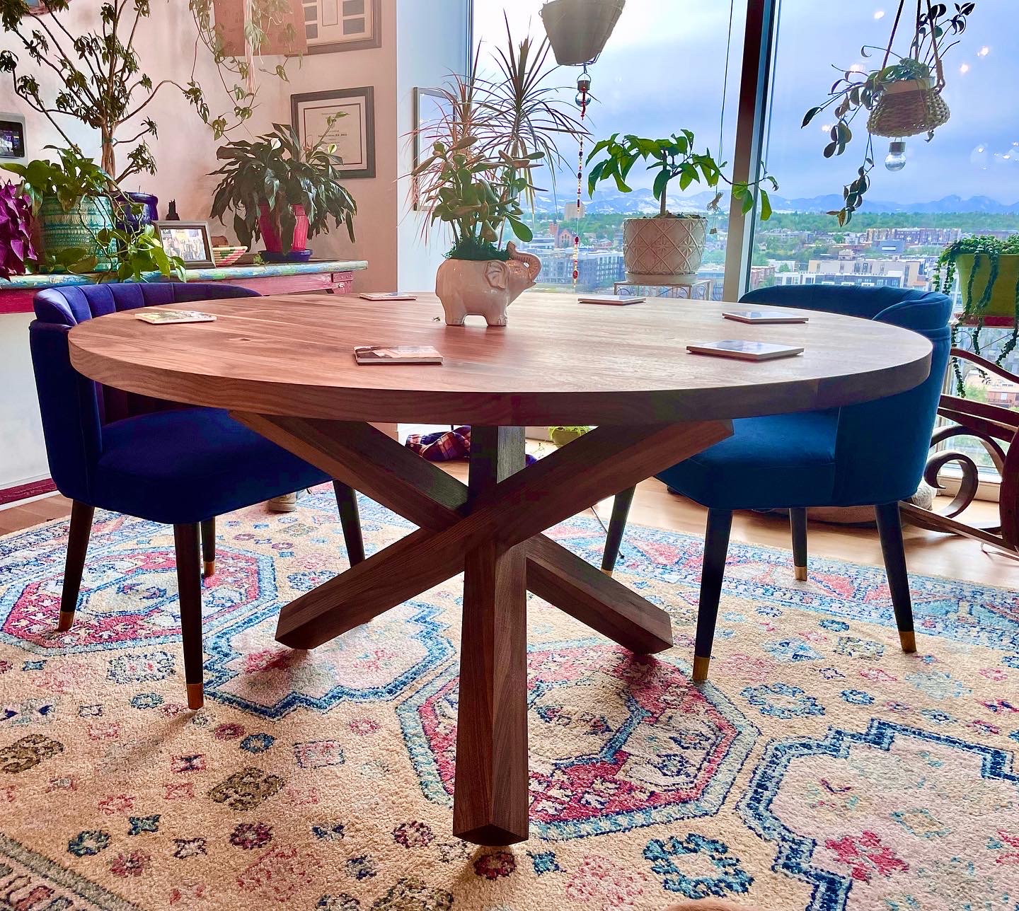 Round dining table featuring puzzle-style interlocked walnut legs by Grillo & Co