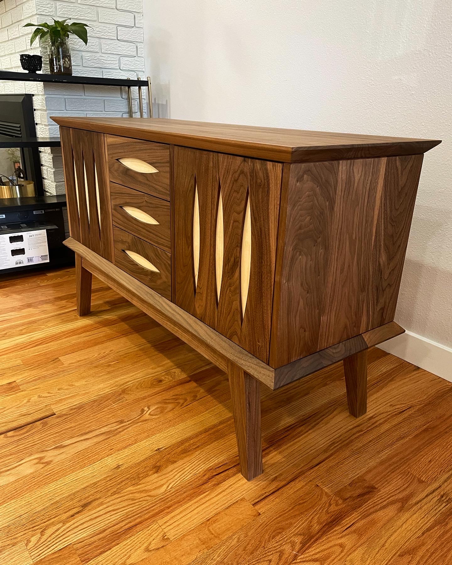 Sleek console table crafted from walnut and maple with cat-eye cutouts by Grillo & Co
